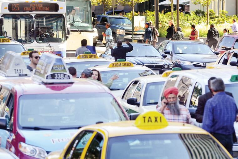 Taxi drivers, unhappy with the possibility that ride-share companies such as Uber and Lyft will be allowed to operate in Philadelphia, protest on JFK Boulevard on October 8, 2014, ( TOM GRALISH / Staff Photographer )