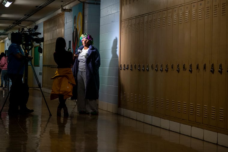 Sheba Grant, the parent of a Building 21 student, is interviewed by news media following the meeting at Strawberry Mansion High School.