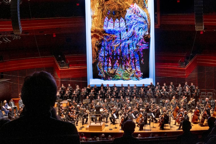 The Philadelphia Orchestra performs under flowing computer images designed by artist Refik Anadol to produce a real-time installation using digital media, data, and artificial intelligence in response to the orchestra's performance of Beethoven's Missa Solemnis on Thursday.