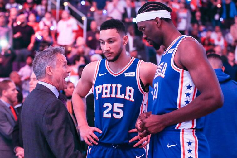 Sixers’ coach Brett Brown talks with Ben Simmons and Joel Embiid before their game with the Wizards at the Capital One Arena in Washington, DC, Wednesday, October 18.