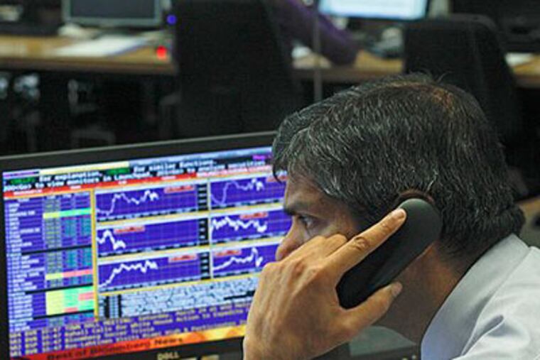 A broker speaks on the phone in a trading room of a Portuguese bank Wednesday, March 21, 2012 in Lisbon. (AP Photo / Francisco Seco)