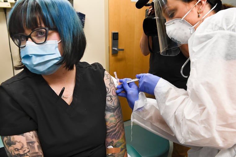 Nurse Kath Olmstead (right) gives volunteer Melissa Harting, of Harpersville, N.Y., an injection as the world's biggest study of a possible COVID-19 vaccine, developed by the National Institutes of Health and Moderna Inc., starts Monday, July 27, in Binghamton, N.Y.