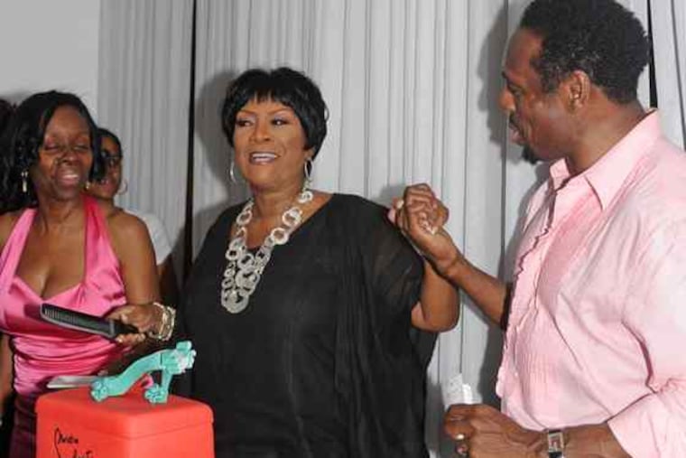 Patti LaBelle marks her 65th birthday with KeVen Parker (right) at his South Street restaurant, Ms. Tootsie's. The cake, created by Chestnut Hill's Night Kitchen Bakery to reflect LaBelle's love for footwear, was cut last Sunday.