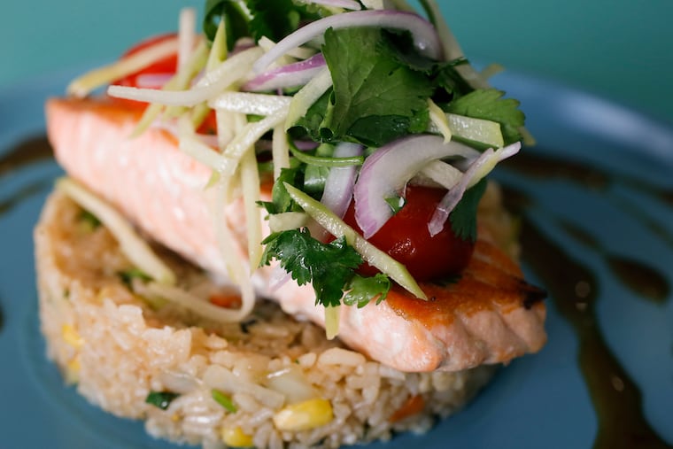 The Salmon Chino-Latino, a pan roasted salmon, vegetable fried rice, sweet chili sauce and chayote salad served at Izlas Latin Cuisine in the Plaza Americana on the 2700 block of North American Street on Friday, April 23, 2021. Izlas Latin Cuisine is participating in the Dine Latino Restaurant Week., running from Sept. 18-22.