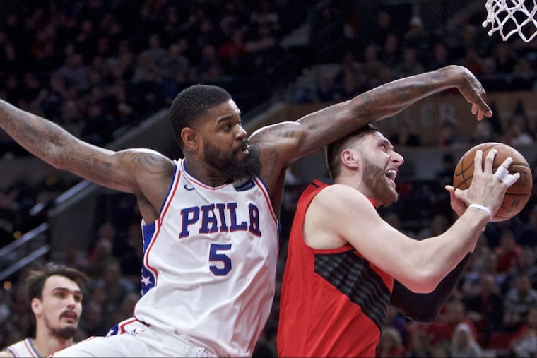 Trail Blazers center Jusuf Nurkic (right) gets fouled by the 76ers’ Amir Johnson during the first half.