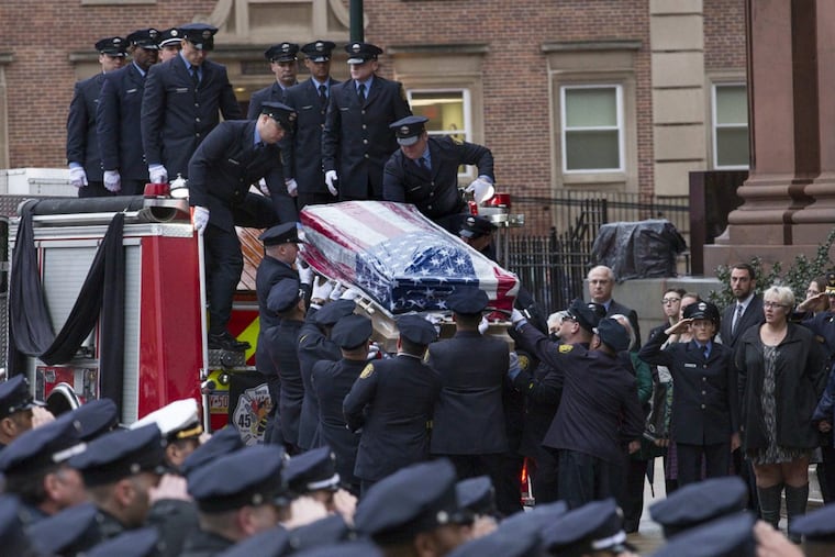 Philadelphia fire fighters lower the body Lt. Matthew LeTourneau, 42, from a fire truck outside the Cathedral Basilica of Saints Peter and Paul in Center City Philadelphia on Friday, January 12, 2018. Lt. Matthew LeTourneau, 42, died fighting a North Philadelphia row house fire.