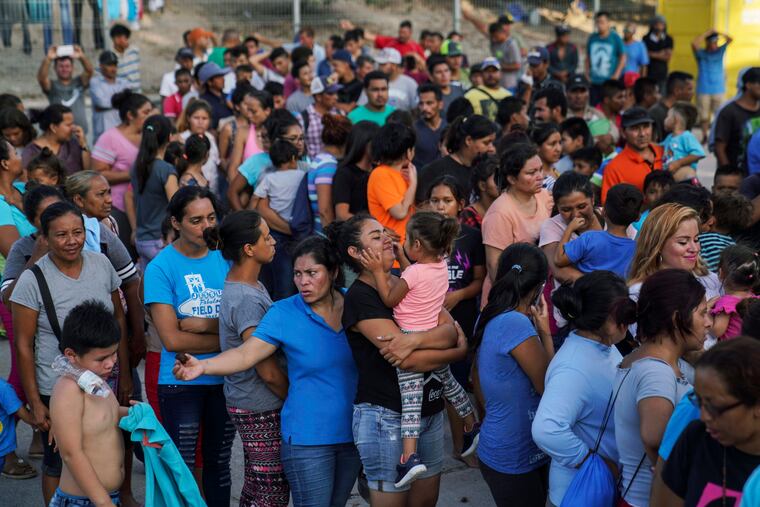 Migrants, many who were returned to Mexico under the Trump administration's "Remain in Mexico," program wait in line to get a meal in an encampment near the Gateway International Bridge in Matamoros in August 2019.
