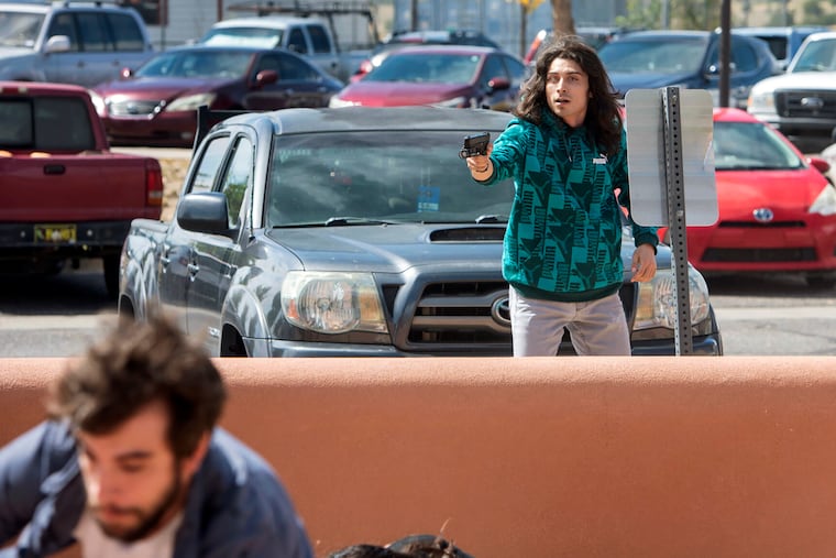 A man who identified himself to the Albuquerque Journal as Ryan Martinez, of East Mountains, pulls a gun during a rally outside the Rio Arriba County building in Española, N.M., Thursday, Sept. 28, 2023. The man scrambling at lower left was not shot. (Eddie Moore/Albuquerque Journal via AP)