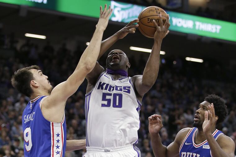 Sacramento forward Zach Randolph puts up a shot between Sixers Dario Saric (left) and Joel Embiid.