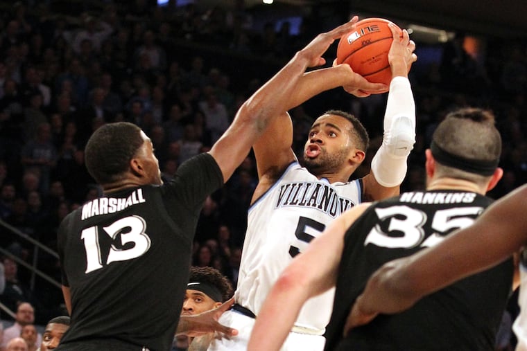 Phil Booth, center, of Villanova shoots between Naji MArshall, left, and Zach Hankins of Xavier during a Big East Tournament semifinal game on March 15, 2019.
