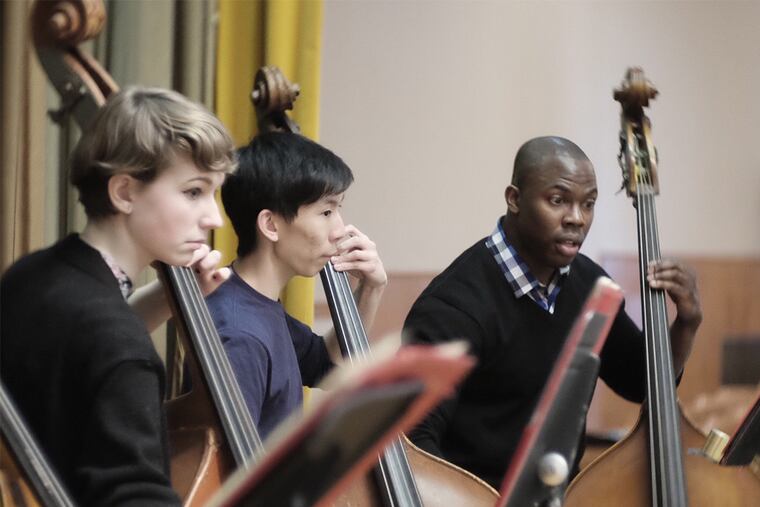 Famed double bassist Joseph Conyers, whose organization Project 440 has taken over the school district's All City Orchestra program, works with members of the bass section during rehearsal. ( ED HILLE / staff photographer )