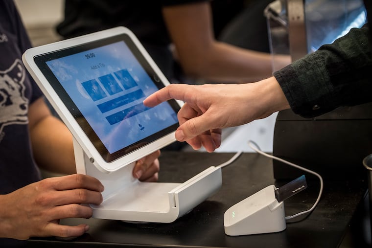 A customer uses a Square Inc. device to make a payment. Bloomberg photo by David Paul Morris