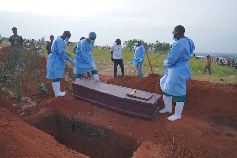 People dressed in protective gear prepare to lower into a grave the coffin containing the remains of six-year-old Baudjo Baraka Jules, who died of Ebola, in Bunia, Ituri province, eastern Congo, on Aug. 18, 2026.