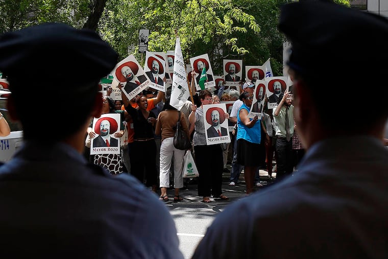 Police officers watch as city-employed union members protest in May 2013. Despite problems in the past, Philly cops have been praised recently for the restraint they've shown at protests. (DAVID MAIALETTI / STAFF PHOTOGRAPHER)