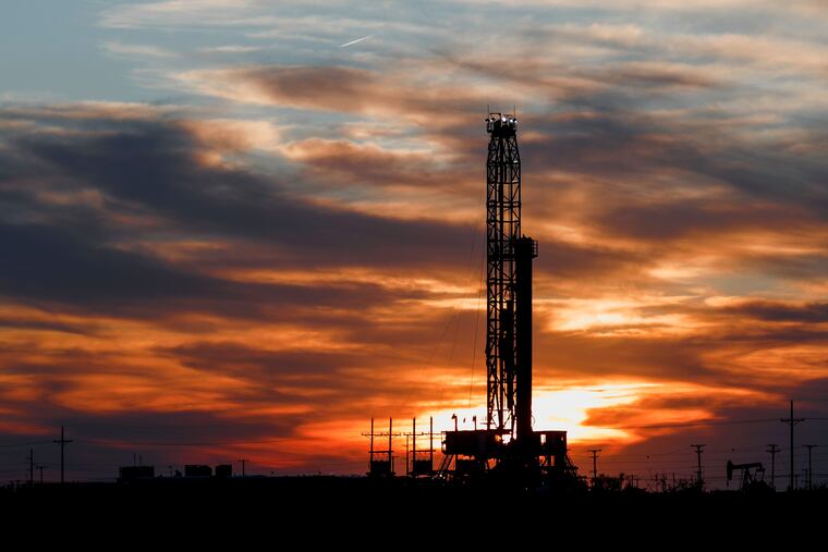 An oil rig stands against the setting sun in Midland, Texas. The price of oil tumbled Monday into negative value.