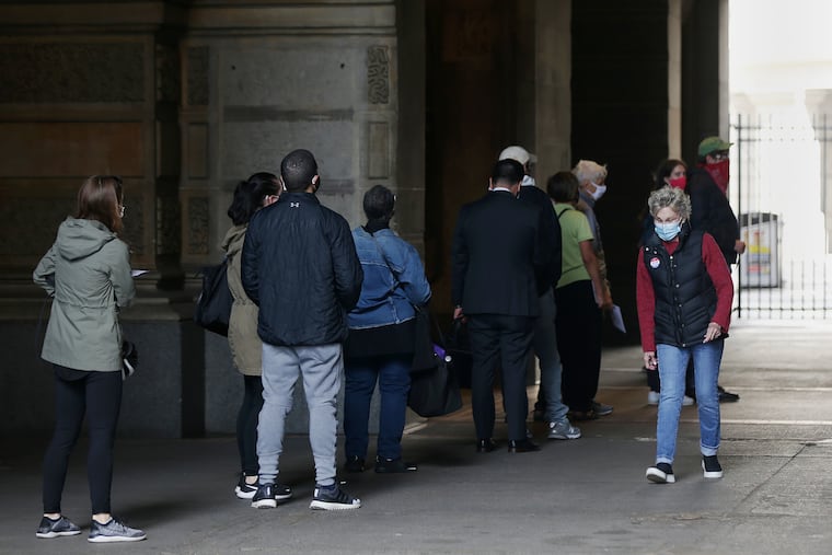 People wait in line Friday outside Philadelphia City Hall, where the main elections office, along with new satellite elections office, allow people to request and submit mail ballots in person.