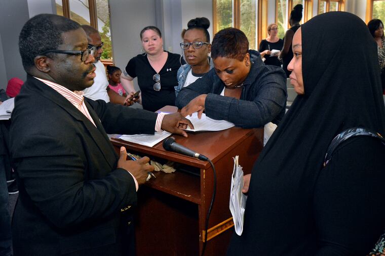 Eastern University Academy Charter School Principal and CEO Omar Barlow addresses questions from parents during a meeting at the school on Aug. 8.