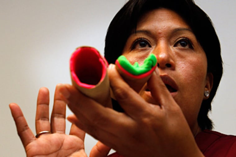 Isabel Garcia, a promotora, demonstrates the effects of diabetes on arteries. (Michael S. Wirtz / Staff Photographer)