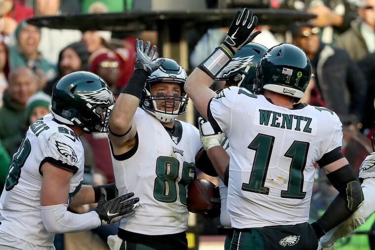 Carson Wentz (right), Zach Ertz (center) and Dallas Goedert (left) celebrate during the fourth quarter of the Eagles' 37-27 win at Washington.