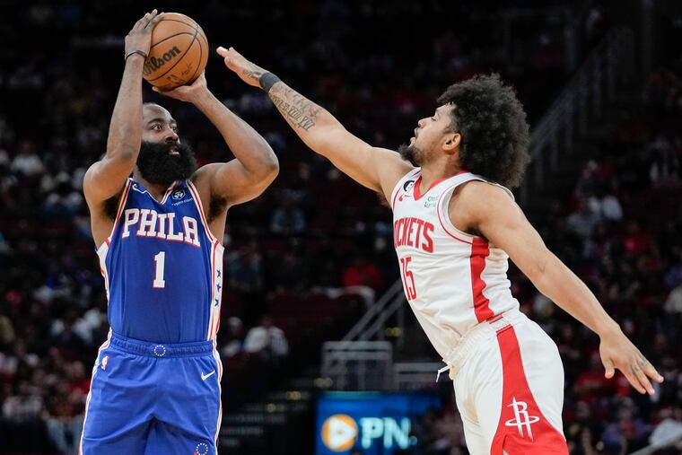 James Harden shoots a three-point basket as Houston Rockets guard Daishen Nix defends during the first half.