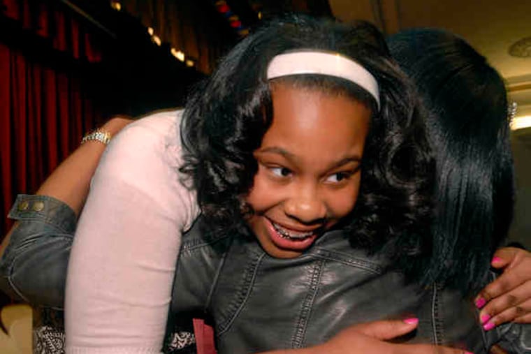 Sowsan Salaam of West Philadelphia gets a hug after winningthe regional spelling competition held at the Free Library. She claimed a spot in the national bee by spelling "ubiquitous."