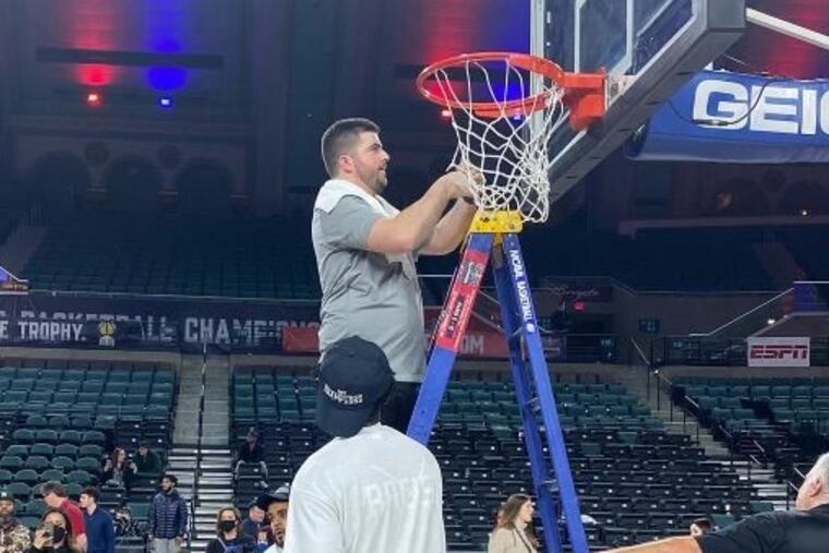 St. Peter's assistant Ryan Whalen cuts down the net after the Peacocks won the MAAC title.