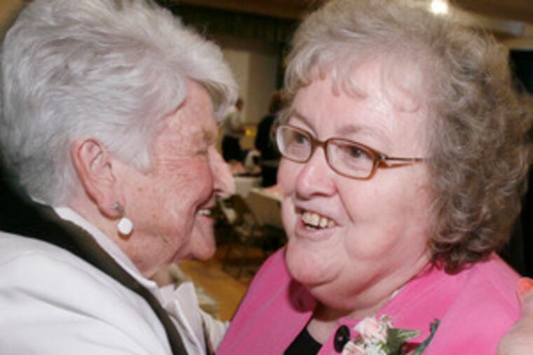 Mary Jane McCormick (right) greets a guest at a dinner and tribute at St. Matthew's parish hall in Mayfair.