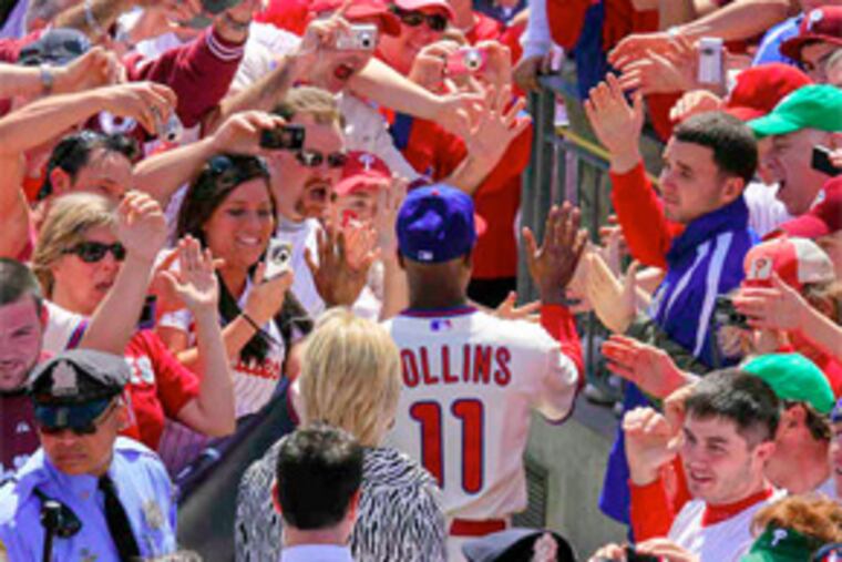 Shortstop Jimmy Rollins greets fans as he enters through the crowd, as did the rest of the team. He later strained his calf while warming up. (Akira Suwa / Staff Photographer)