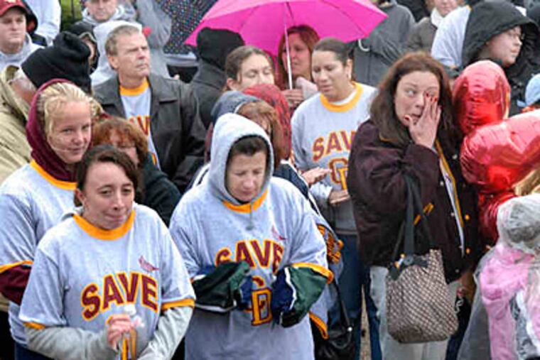 Donna Hural wipes an eye at the school. Next to her is 1988 alumna Margaret Malone, with her daughter, sophomore Anne Mae Wieckowski. (April Saul / Staff)