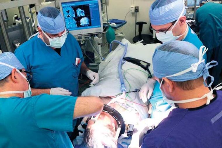 Surgeons at Jefferson University Hospital plot the location where they will be drilling a hole into the head of patient Christopher Teti. The device they are using to map out the various points of his head relies on infrared sensors.