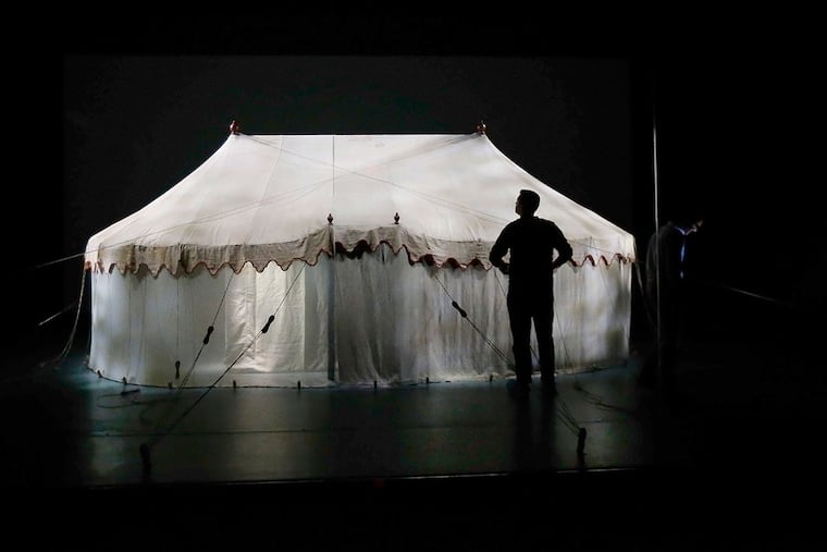 Ryan Will, exhibit preparator, looks over the tent as they attach the ropes around George Washington's tent.