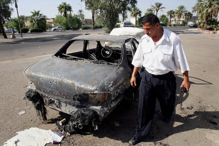 FILE - In this Sept. 25, 2007 file photo, an Iraqi traffic policeman inspects a car destroyed by a Blackwater security detail in al-Nisour Square in Baghdad, Iraq. A federal jury convicted four former Blackwater security guards in 2014 for the killing and wounding of 31 Iraqis civilians in the heart of Baghdad. President Donald Trump on Tuesday, December 22, 2020, pardoned 15 people, including the four Blackwater contractors.