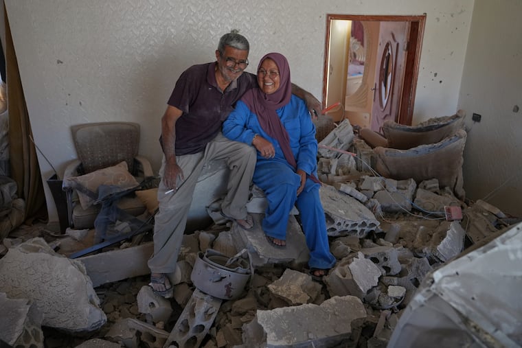 Mahasen Faqih and her husband, Mohammed Sobeih, smile as they sit amid the rubble of their home in Zawtar al-Gharbieh, Lebanon, on Tuesday after returning to it following the Israeli military operation.