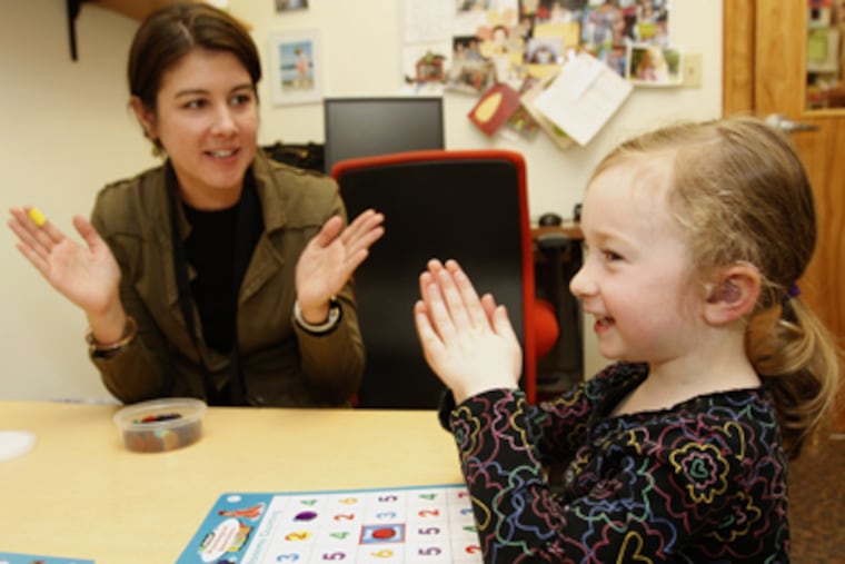 Sarah Gross, 4, right, claps out the syllables in words as she works with Cara Luliano, a speech and language pathologist at the Clarke School in Bryn Mawr. (Charles Fox / Staff Photographer)