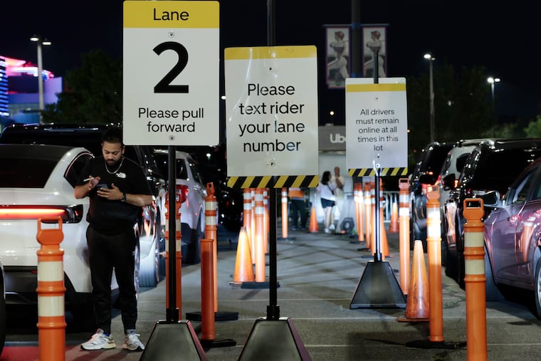 An Uber driver watches his phone while parked in Lot T after the Mets vs. Phillies game at Citizens Bank Park in Philadelphia in June 2025.