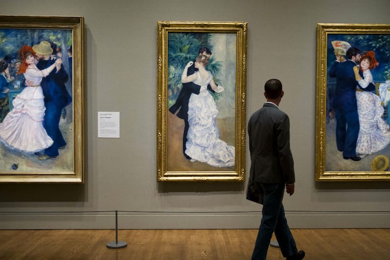 You(and this guy) will feel a lightness in your step as you walk past the paintings of dancing couples by Pierre-Auguste Renoir. (Matt Rourke/Associated Press)