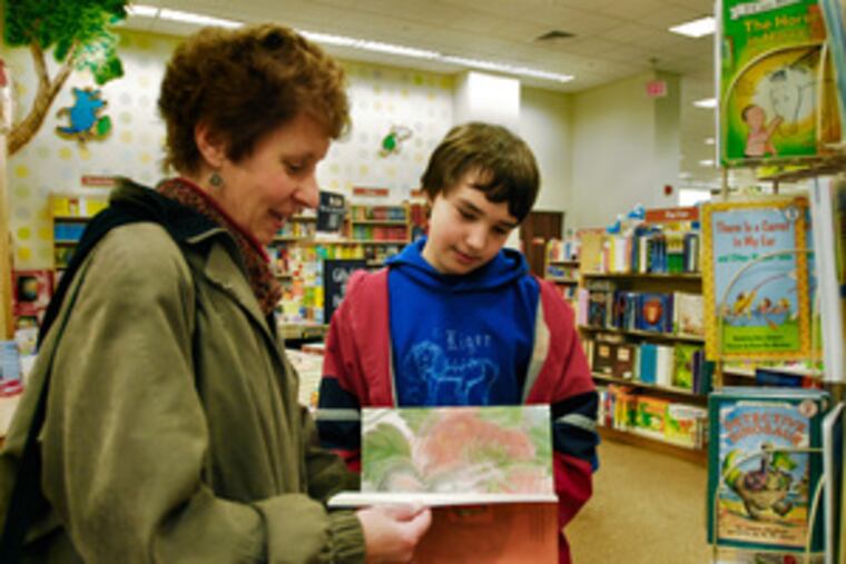 Janet Woods and son Alex of Roxborough look at children's offerings at Barnes & Noblein Plymouth Meeting. Alex, 11, says gift cards give him the freedom to "choose what I want."