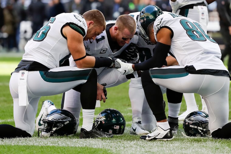 Eagles tight end Zach Ertz, quarterback Carson Wentz, tight end Dallas Goedert and wide receiver Jordan Matthews pray before they played the Jacksonville Jaguars at Wembley Stadium in London in October 2018.