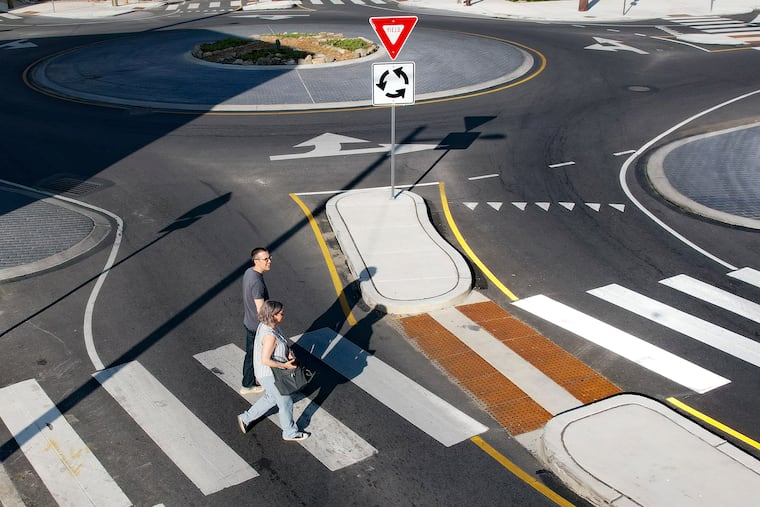 Pedestrians cross the street at a roundabout at the intersection of York Street and Trenton and Frankford Avenues in Fishtown.