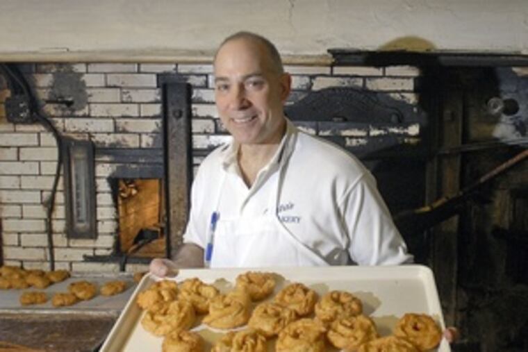 Louis Testa of Testa's Bakery shows off the year's first zeppoles, made March 1. They're filled with ricotta cheese or vanilla or chocolate cream.