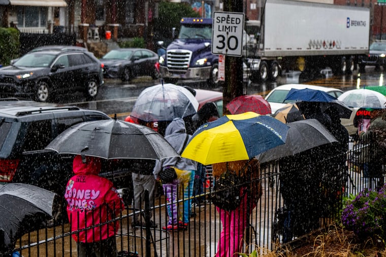 Kensington residents line up outside the Cornerstone Community Church before the opening of their weekly food pantry on Thursday.