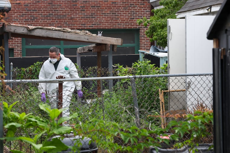 An investigator searches the backyard of the house at 417 W Chew, in Olney home in Philadelphia, June 27, 2026.