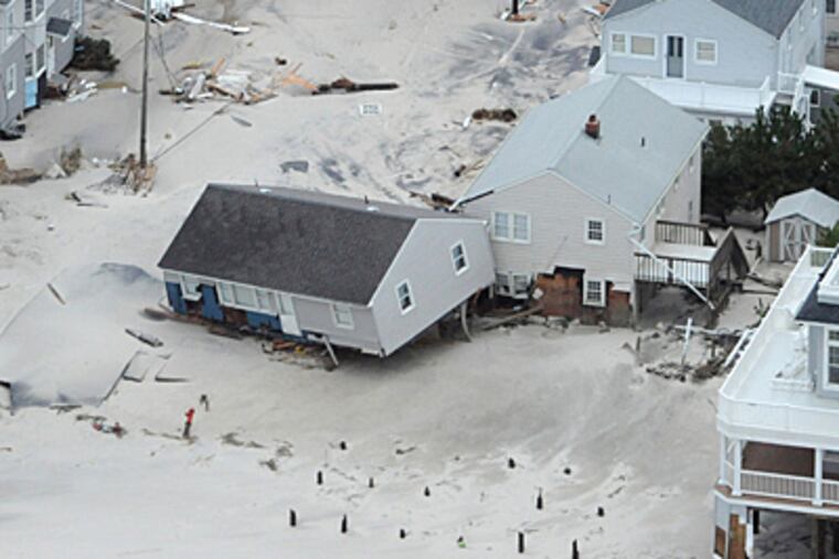 Hurricane Sandy's devastation shows in the Brandt Beach area on the southern end of Long Beach Island as a beach house is washed off its foundation on Tuesday. ( CLEM MURRAY / Staff Photographer )