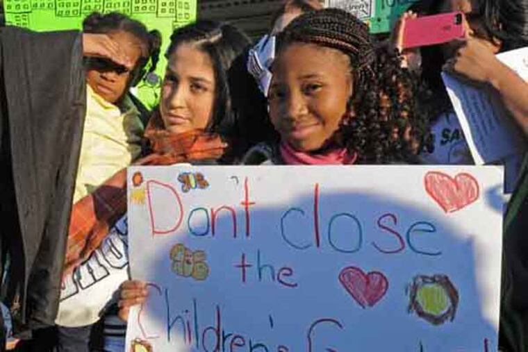 In Camden, a press conference at the Camden Children's Garden to announce that it will remain open on Feb. 12, 2013. Here, from left to right, Dai'onni Russell, 6; Sandra Meneces; and Bryanna Graham, 12; at the press conference. ( APRIL SAUL / Staff Photographer )