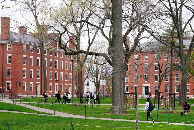Students walk through Harvard Yard on April 27, 2022, on the campus of Harvard University in Cambridge, Mass.