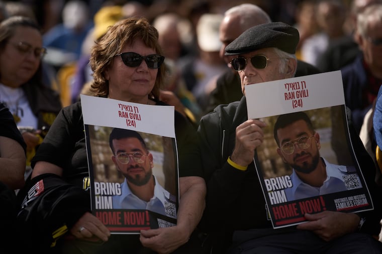 People hold signs with a photo of Ran Gvili, who was killed while fighting Hamas militants during the Oct. 7, 2023, attack and whose body has been held in Gaza ever since, during a rally calling for his return in Tel Aviv, Israel, Friday, Jan. 23, 2026.
