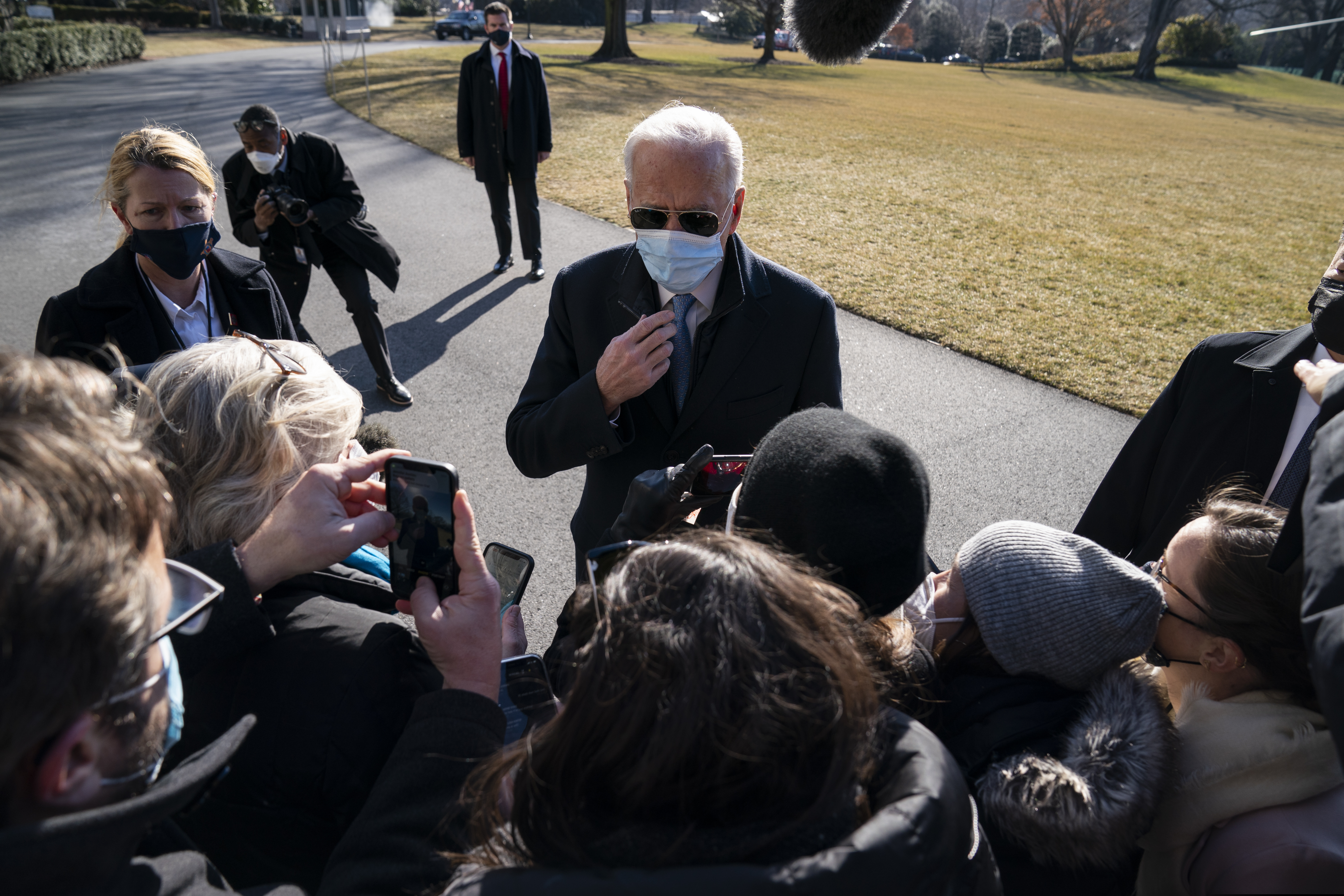 President Joe Biden talks with reporters on the South Lawn of the White House.