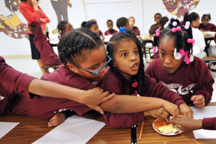 First graders (from left) E'myah Herring, Mya Nicholson, and Ja'Niyah Van, all 6, taste sweet potato dip at Douglass Christian School. (Sharon Gekoski-Kimmel / Staff Photographer)