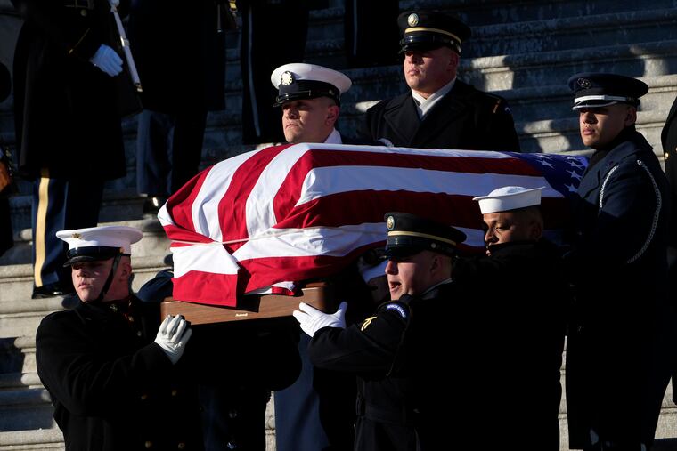 A joint services body bearer team carries the flag-draped casket of former President Jimmy Carter from the U.S. Capitol in Washington, before heading to the Washington National Cathedral.
