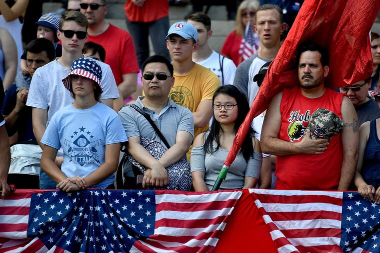 A crowd on the steps of the National Archives observe a moment of silence while Taps plays at the 2018 Memorial Day Parade in Washington.